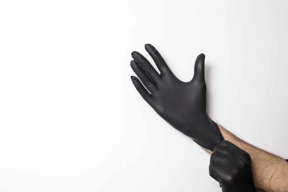 Medical,black,gloves,on,a,male,hand,on,a,white