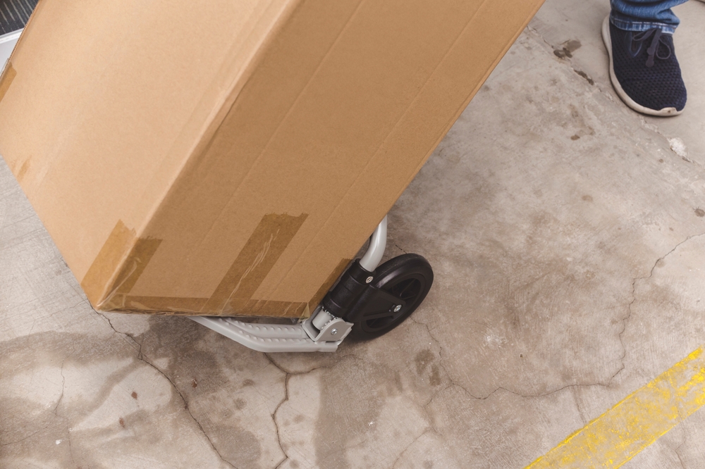 Close Up,of,an,individual,using,a,portable,trolley,to,move