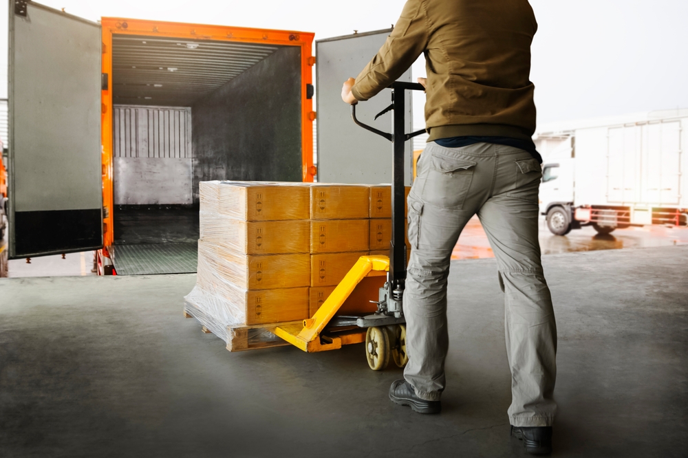Workers,unloading,packaging,boxes,on,pallets,into,the,cargo,container
