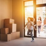 Happy,family,with,cardboard,boxes,in,new,house,at,moving